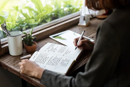 Closeup of girl writing on her journal